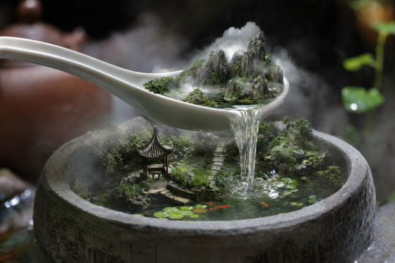 超现实微缩瀑布场景，置于瓷勺中并悬浮在石质水缸上方